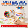 A hand holds a white plastic container of silicone crayons for kindergarten use with colorful tips and an elephant design.