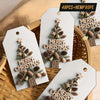 White farmhouse Christmas gift tags featuring gold bells and pinecone cutouts tied with hemp rope