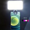 A portable rechargeable mini selfie light illuminates a smartphone displaying a gradient color effect.