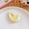 A small, light yellow cat paw-shaped mini cutter is placed on a white plate.