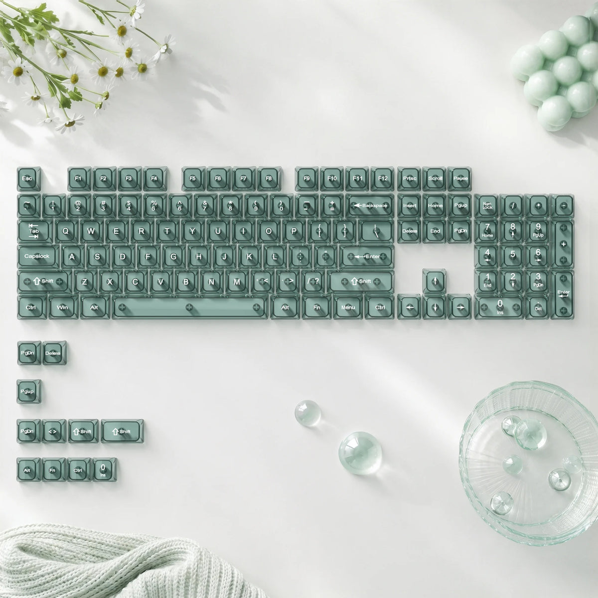 A close-up of crystal clear RGB keycaps for a mechanical keyboard arranged on a white surface.