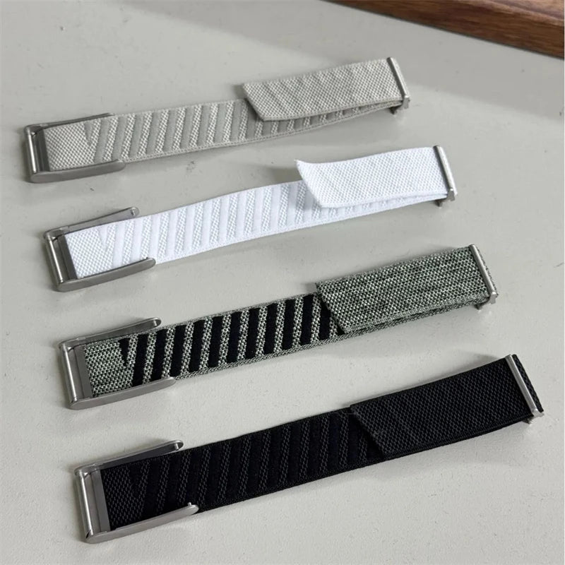 Three replacement watch bands for a Whoop 5.0 device in silver, white, and black nylon braiding.