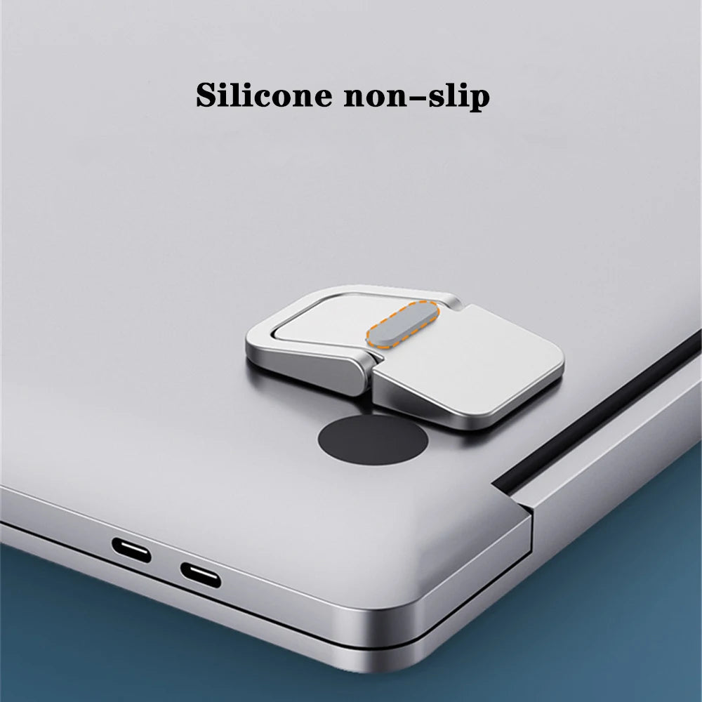 Primer plano de un accesorio de silicona antideslizante unido al borde de una laptop plateada.
