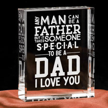 A clear glass block engraved with the text Any man can be a father but it someone special to be a dad I love you