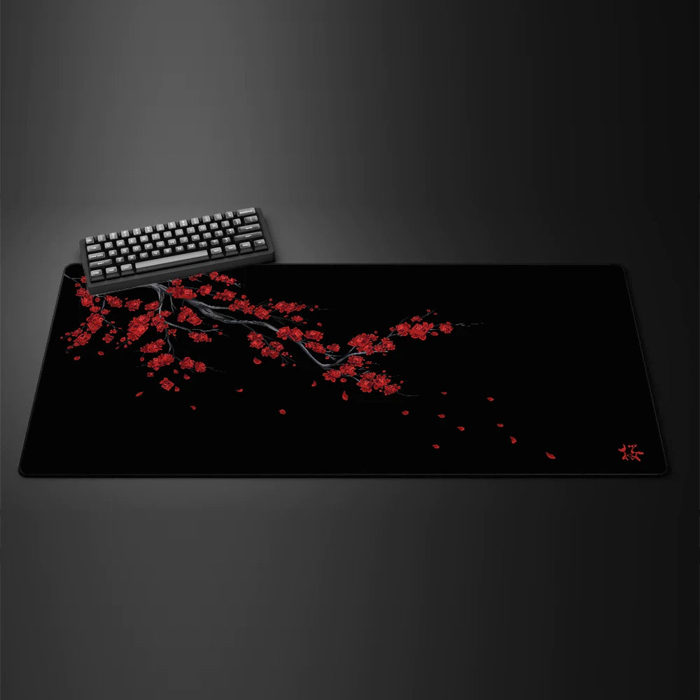 Black gaming mouse pad featuring a red cherry blossom branch design and a black mechanical keyboard.