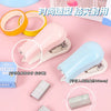 A pink cartoon mini stapler is shown with various sizes of metal staples, demonstrating its use for students and office work.