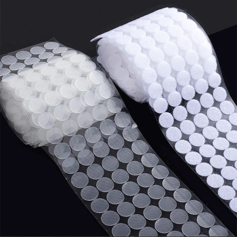 Rolls of white self-adhesive hook and loop fasteners with various sizes shown on a dark background