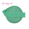 A green bristleglass elastic hair tie with a matching green band.