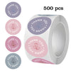 Roll of 500 pastel rose thank you stickers in various shades of purple and pink.