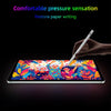 A hand holds a stylus writing on an iPad screen displaying colorful floral patterns.
