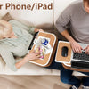 A person is using a pillow stand for a phone or iPad while relaxing on a couch.