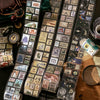 A collection of vintage stamp tape stickers and ephemera laid out on a dark wooden surface.