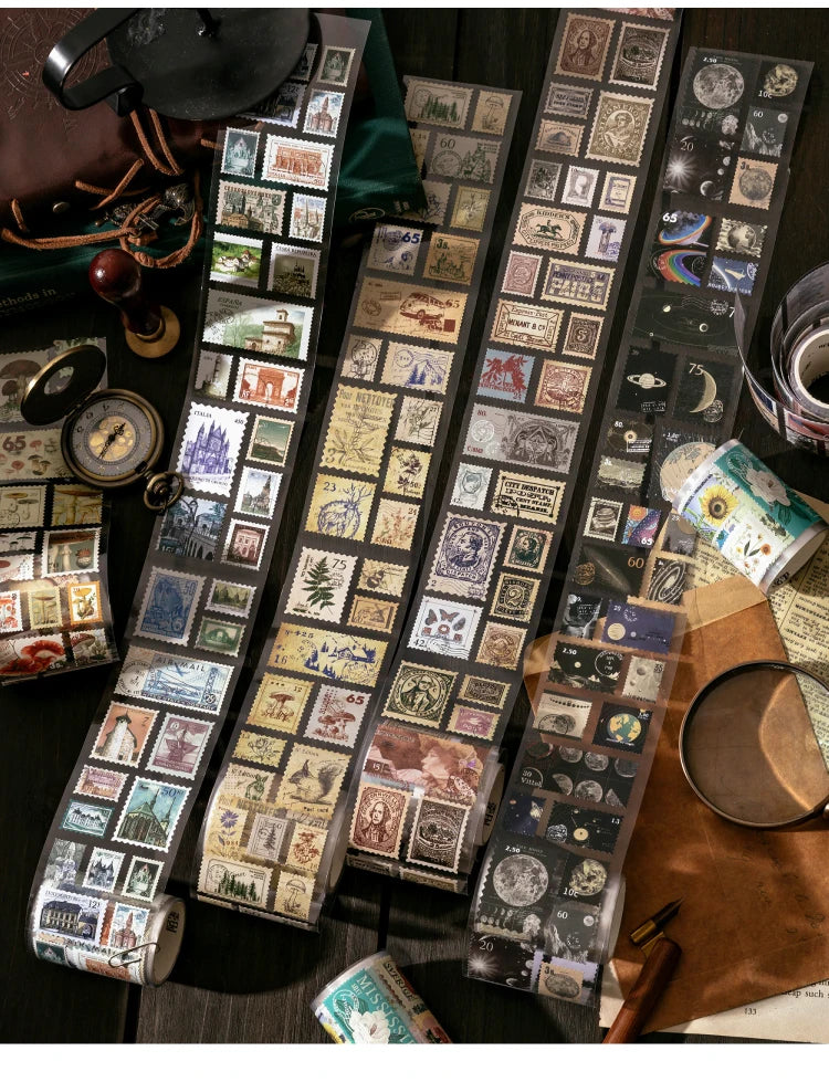 A collection of vintage stamp tape stickers and ephemera laid out on a dark wooden surface.