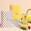 A set of yellow and white polka dot reusable PU leather binders and a fluffy yellow charm.