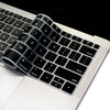 A close-up view of a silicone keyboard cover placed on a white laptop, showing the keys and surrounding area.
