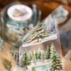 A watercolor illustration of a snowy forest landscape featuring evergreen trees and winter scenery.