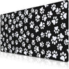 Black desk mat featuring a repeating pattern of white paw prints.