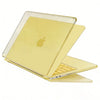 A clear protective case is shown open, displaying a yellow-tinted laptop with a silver keyboard.