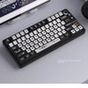 A close-up view of a black mechanical keyboard featuring transparent pudding style PBT keycaps for CSGO gaming.