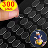 A hand is applying double-sided adhesive fixer pads to a black surface, with a small figure visible in the background.
