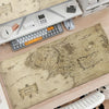 A large beige map of the Middle Earth region is displayed on a desk mat next to a keyboard and mouse.
