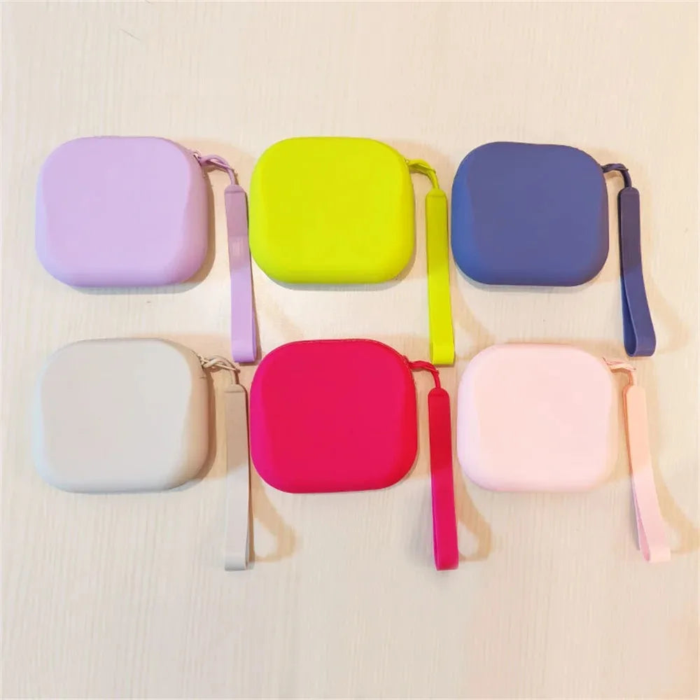 Eine Sammlung von Silikon-Kosmetikbeuteln in verschiedenen Pastellfarben, darunter lila, gelb, blau, rosa und weiß, mit Aufhä