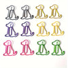 A set of twenty colorful paper clips shaped like sitting dogs used as a cute desk organizer.