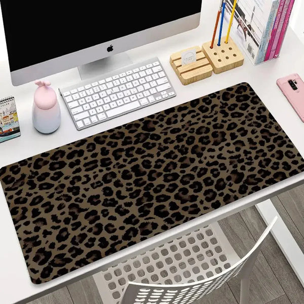 A dark brown leopard print non-slip gaming mouse pad is displayed on a white desk next to a computer monitor and keyboard.