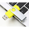A yellow and silver metal USB 2.0 flash drive is shown inserted into a laptop port.