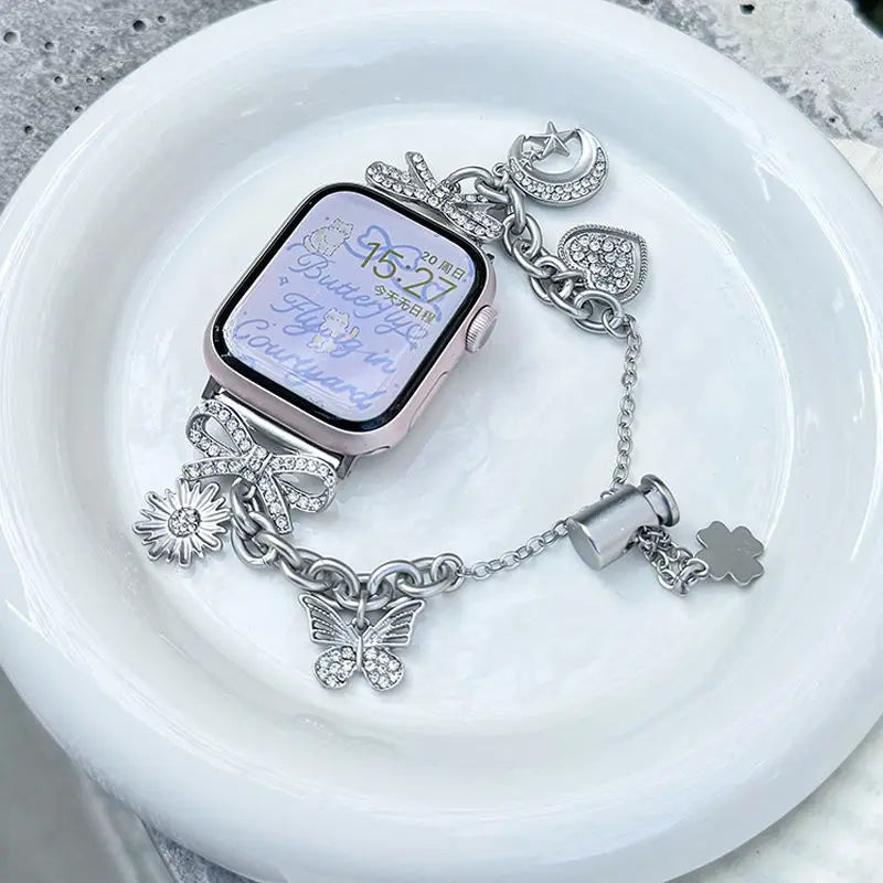 A silver diamond butterfly watch strap is displayed on a white plate.