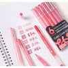 A set of multi-color acrylic painting gel pens in various shades displayed on a spiral notebook.