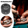 A close-up of a 30X magnifying glass being used to inspect jewelry and coins.