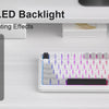 A white membrane keyboard with vibrant RGB LED backlight is shown on a desk.
