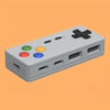 A gray 4-in-1 USB hub with Type-C ports and colored buttons is shown on an orange background.
