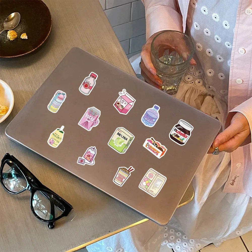 A brown silicone mat features a pack of waterproof cartoon stickers for journaling and decor, held by a person.