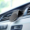 A close-up of a magnetic car air vent phone mount installed in a vehicle's interior