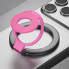 A pink MagSafe double-sided phone ring holder stand resting on a gray surface.