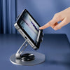 A hand is rotating a mobile phone holder device that supports a smartphone for viewing.
