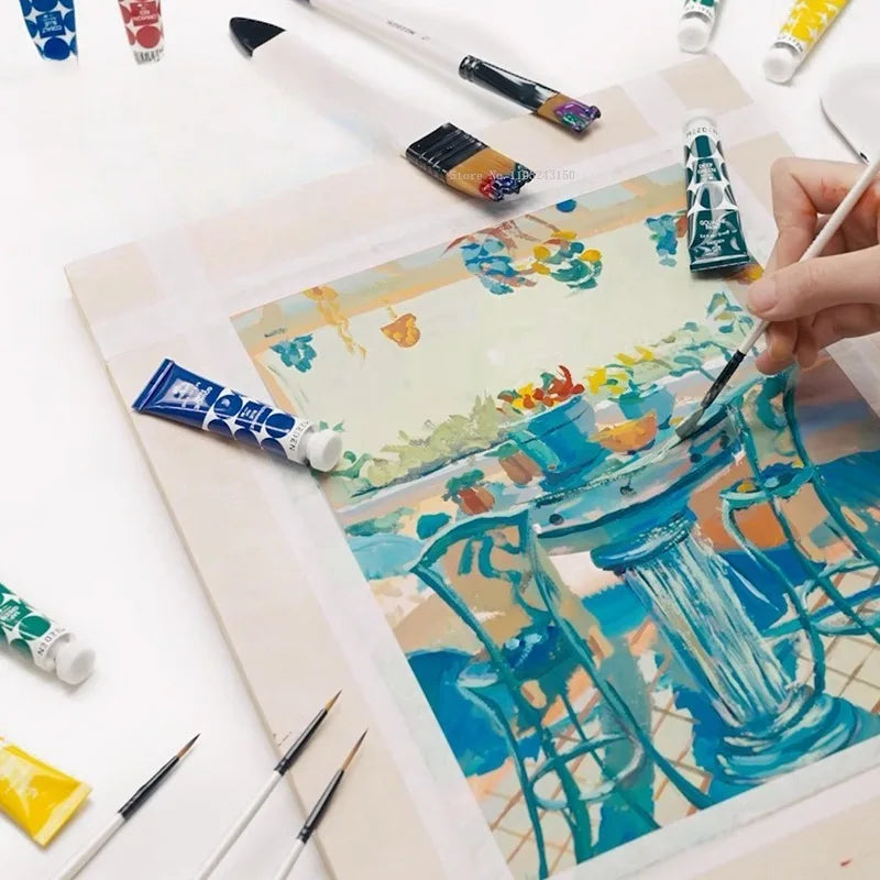 A watercolor painting in progress featuring blue and teal architectural elements on light paper, surrounded by various paint 