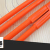 Orange adjustable woodworking marking compass with pencil holder resting on a light wooden surface.