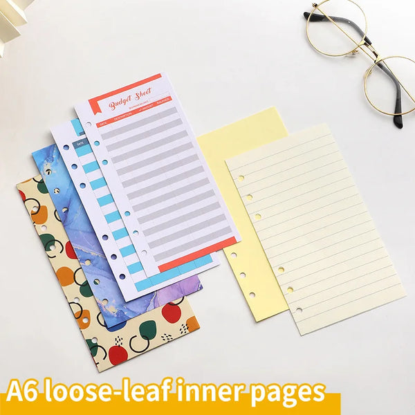 A collection of A6 loose-leaf inner pages including a budget sheet and lined paper in various colors