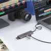 A gray USB-C docking station is shown next to a laptop and a camera lens, demonstrating file transfer capabilities.