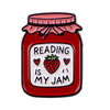 Red enamel lapel pin shaped like a jar with a pink lid and text reading is my jam