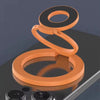 An orange phone ring holder stand with two rings resting on a dark surface.