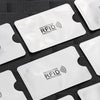 Plusieurs cartes de protection anti-RFID blanches sont présentées sur une surface sombre.