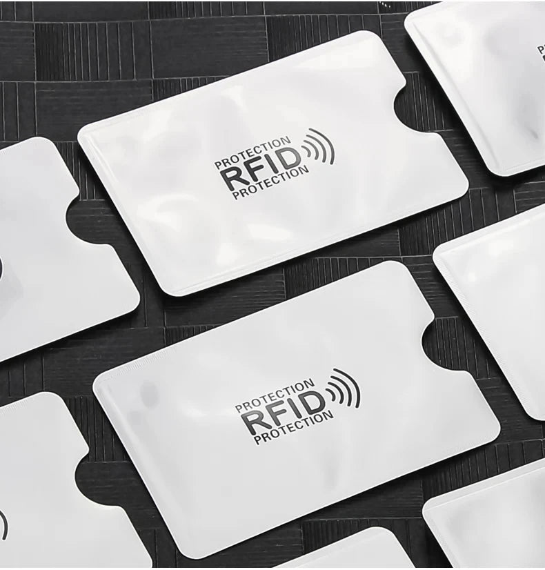 Plusieurs cartes de protection anti-RFID blanches sont présentées sur une surface sombre.