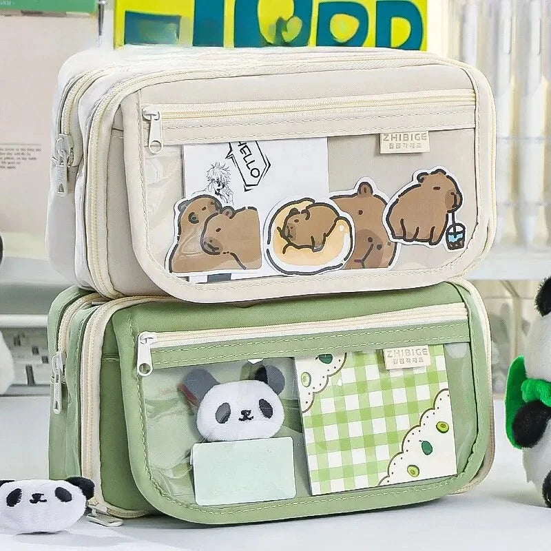 A light green pencil case with a transparent flip pocket featuring cute brown bear illustrations.