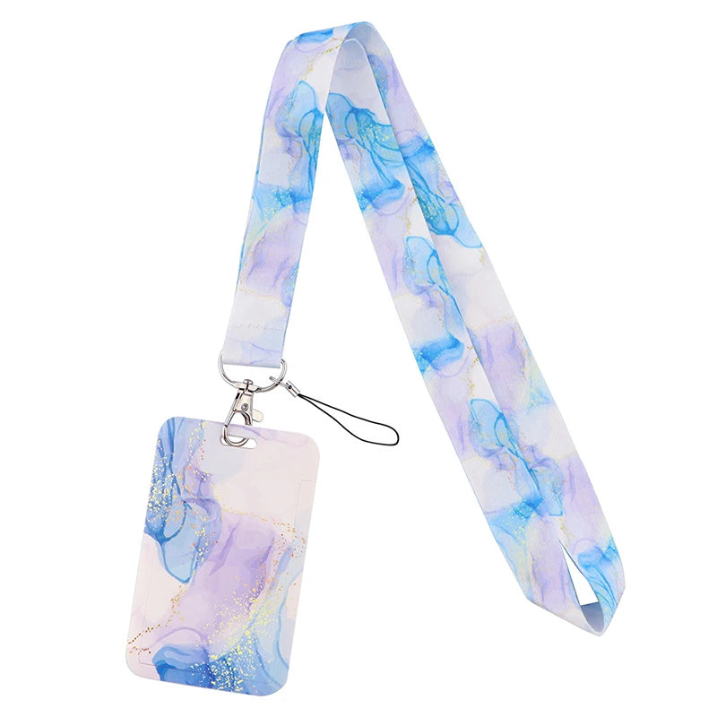 A light purple and blue watercolor patterned lanyard with a clear plastic tag attached.