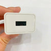 A white rectangular plug with a black slot is held by a hand.