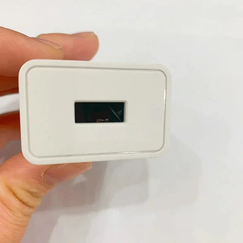 A white rectangular plug with a black slot is held by a hand.